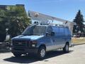 A blue 2008 Ford E-350 van with an elevated work platform attached to the roof