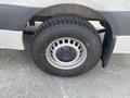 Close-up of a wheel on a 2025 Mercedes-Benz Sprinter featuring a multi-spoke alloy rim and all-terrain tire with a rugged tread pattern