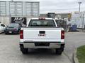 A white 2016 GMC Sierra 1500 truck viewed from the rear showcasing the GMC logo and Sierra lettering on the tailgate