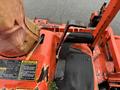 A 2012 Kubota F3680 lawn mower featuring an orange frame a black seat and foot pedals with warning labels and a control lever