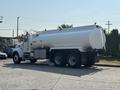 A 2008 Peterbilt 340 tank truck with a large cylindrical tank in the back and dual rear wheels parked on a street