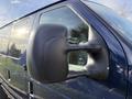 Close-up of a side mirror on a 2011 Ford Econoline van in dark blue color with a glossy finish and a modern design