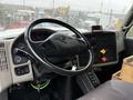 Interior view of a 2011 International 7500 truck featuring a black steering wheel control panel gauges and various buttons and levers