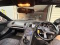 Interior view of a 1997 Toyota Supra showing the steering wheel dashboard gear shifter and various controls