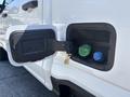 A close-up of the fuel filler door on a 2023 Ford F-350 SD showing two fuel inlet caps one labeled diesel and the other for gasoline