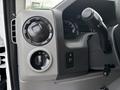 Interior dashboard controls of a 2017 Ford Econoline featuring knobs for lights and vents along with a gear shift lever