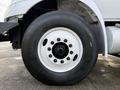 Close-up of a 2012 International DuraStar 4300 tire and wheel showing a large black tire with a white rim and multiple bolt holes