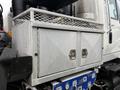 A metal storage cabinet with a mesh top and two doors attached to a 2013 International Workstar 7500 truck