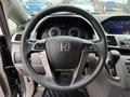 Steering wheel and dashboard of a 2014 Honda Odyssey with digital display and control buttons visible