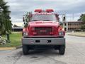 Red 2002 GMC C7500 fire truck with a prominent grill and emergency lights on the roof facing forward