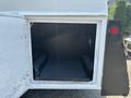 An open storage compartment of a 2006 Sterling Acterra truck showcasing a black interior with sliding shelves and no contents visible