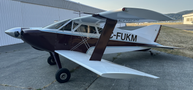 A 1986 Sorrell Hiperbipe SNS-7 Amateur-Built Aircraft featuring a distinctive design with a maroon and white color scheme and large wings positioned in a parked stance