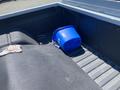 A blue bucket placed inside the cargo bed of a 1962 Ford 2WHDR truck with a textured black surface