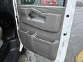 The interior door panel of a 2016 GMC Savana featuring a handle multiple storage compartments and an armrest