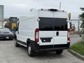 A 2020 RAM Promaster van with a white exterior and black rear doors parked in a lot