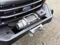 A 2001 Ford F-350 front bumper with a mounted winch and steel cable visible on the front plate