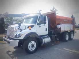 A 2016 International WorkStar 7500 truck with a white cab and an orange dump bed equipped for transporting materials