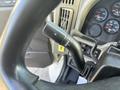 Close-up of the steering column controls in a 2008 International 4400 with a focus on the turn signal lever and dashboard gauges showing speed and other indicators