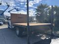 A 2014 RAM 5500 with a wooden flatbed and black frame positioned on a concrete surface