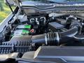 A close-up view of the engine compartment of a 2020 Ford F-350 showing the air intake system and dual green batteries