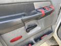 Close-up of the interior door panel of a 2009 Dodge Ram 5500 featuring a black handle and buttons with red tape applied over the control panel