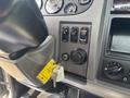 Dashboard controls of a 2020 Peterbilt 330 including buttons for cruise control and a key ignition with a yellow key tag