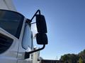 A 2013 International 7500 truck with a prominent mirror extending from the driver's side, showcasing its robust design and rugged features