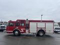 A red 2006 E-One fire truck with a white stripe and various compartments for firefighting equipment