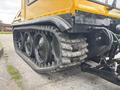 A close-up view of the tracks and rear of a 2004 Bombardier SW48 with three large wheels and heavy-duty rubber tracks visible on the undercarriage