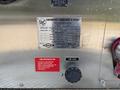 A metallic plaque attached to a 1999 Freightliner FL80 displaying specifications and pump ratings for a fire department pump including various technical details