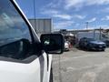 A 2021 Ford F-150 with a side mirror reflecting the surroundings and showing a clear view of the nearby vehicles and structures