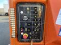 Control panel of a 2012 JLG E400AJFN featuring various buttons and switches for operating the equipment with a key ignition and safety indicators