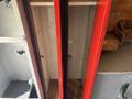 A 2011 Workhorse W62 vehicle with two open storage compartments featuring red doors and interior hooks