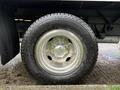 Close-up of a shiny chrome wheel and tire from a 2013 Ford Econoline showing tread details and wheel design