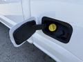 Close-up of the fuel door on a 2021 Ford F-250 SD showing a yellow fuel cap and the compartment with the door opened