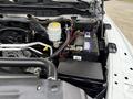 Close-up of the engine compartment of a 2013 RAM 3500 showing the battery and various components including a coolant reservoir and wiring