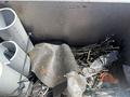 A 2017 Chevrolet Express partially visible inside a container filled with various materials including plastic pipes and metal wires