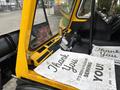 A yellow Bombardier SW48 vehicle's interior with a dashboard displaying controls and a sign that reads Thank You Its Been A Pleasure Serving You