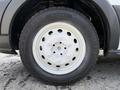 Close-up of a silver alloy wheel with multiple circular cutouts and a black tire labeled 195/75 R 16 C