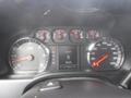 A close-up view of the dashboard of a 2015 Chevrolet Silverado 1500 showing speedometer and tachometer readings along with various indicator lights and controls