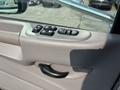 A close-up view of the driver's door panel of a 2020 Peterbilt 330 featuring window control buttons and a door handle