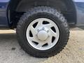 Close-up of a Goodyear Wrangler tire mounted on a silver alloy wheel of a 2013 Ford E-350 Super Duty