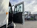 A 2012 International DuraStar 4300 with its driver's side door open showing the interior of the cab and the side mirror