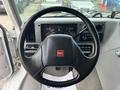 Steering wheel of a 1994 GMC Vandura 3500 featuring the GMC logo and dashboard gauges behind it with various controls and a radio display