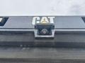 Close-up of a 2012 Caterpillar 980 vehicle showing the CAT logo and a forward-facing camera mounted on the front grille
