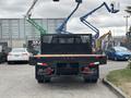 A 2023 Ford F-450 Super Duty with a flatbed equipped with a black mesh guard facing towards the viewer