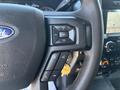 Steering wheel controls of a 2019 Ford F-550 displaying buttons for volume navigation and other functions