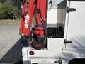 A 2006 International 4300 truck with a red crane attachment visible in the foreground