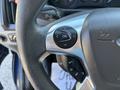 Close-up of a steering wheel in a 2016 Ford Transit 150 featuring a control panel with buttons for navigation and settings