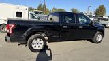 A black 2016 Ford F-150 pickup truck with a crew cab and four wheels parked on a lot